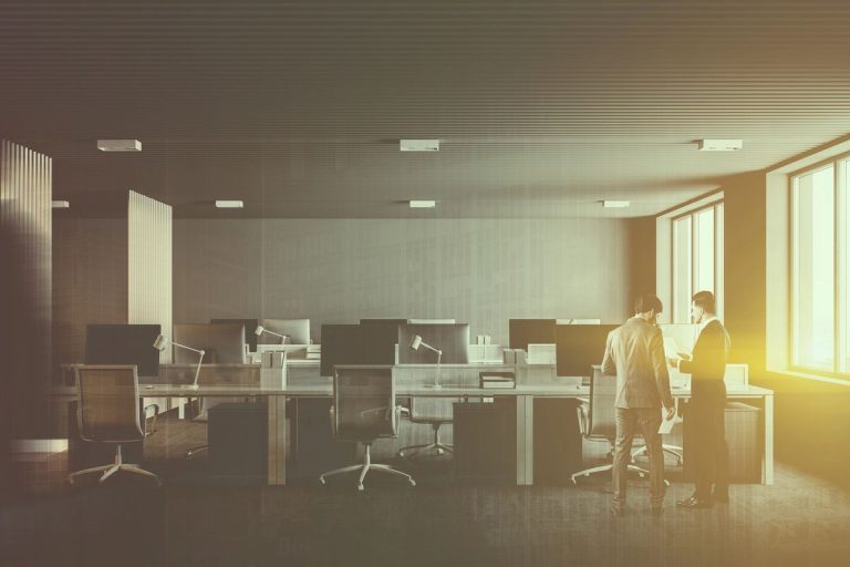 VistaCreate 203875032 stock photo businessmen talking open space office interior rows computer desks white 768x512