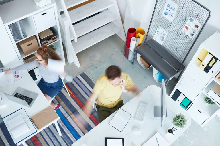 VistaCreate 248207130 stock photo top view busy office managers working desks studio design 768x512