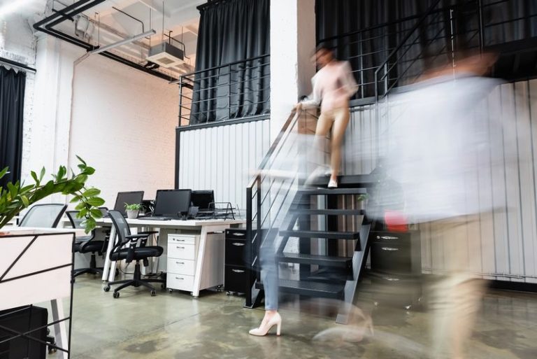 VistaCreate 423884910 stock photo motion blur businesswomen businessman walking modern office computers 768x513